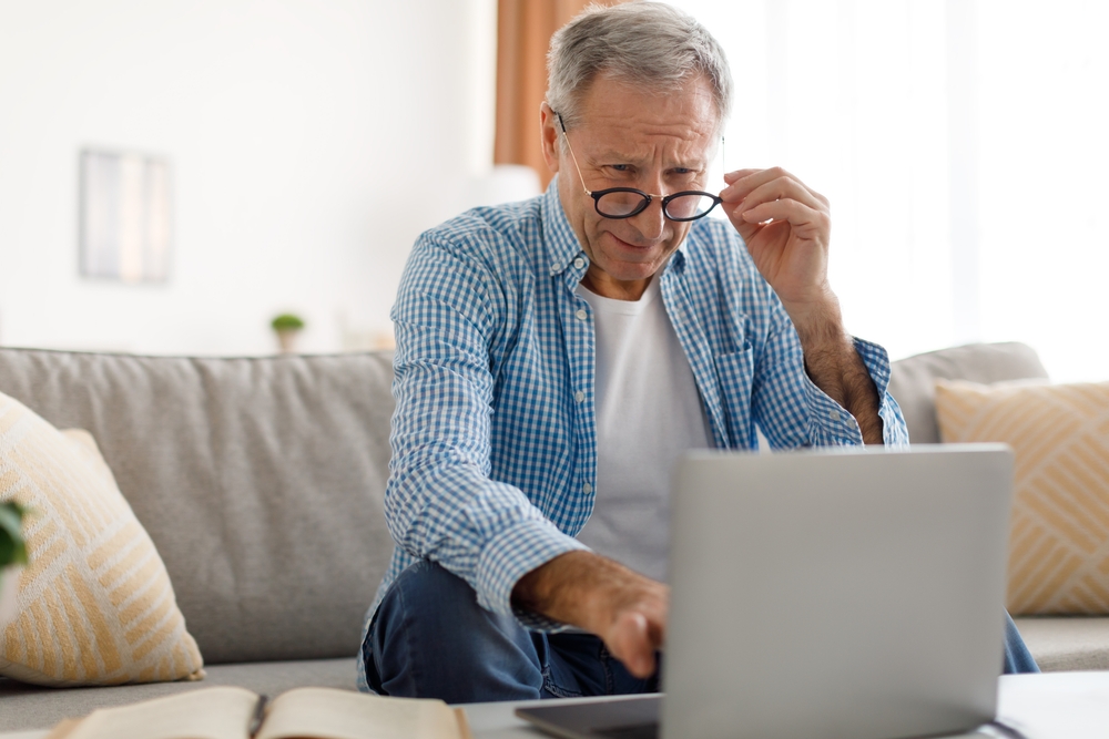 Poor,Eyesight.,Senior,Man,Squinting,Eyes,Using,Laptop,Wearing,Eyeglasses